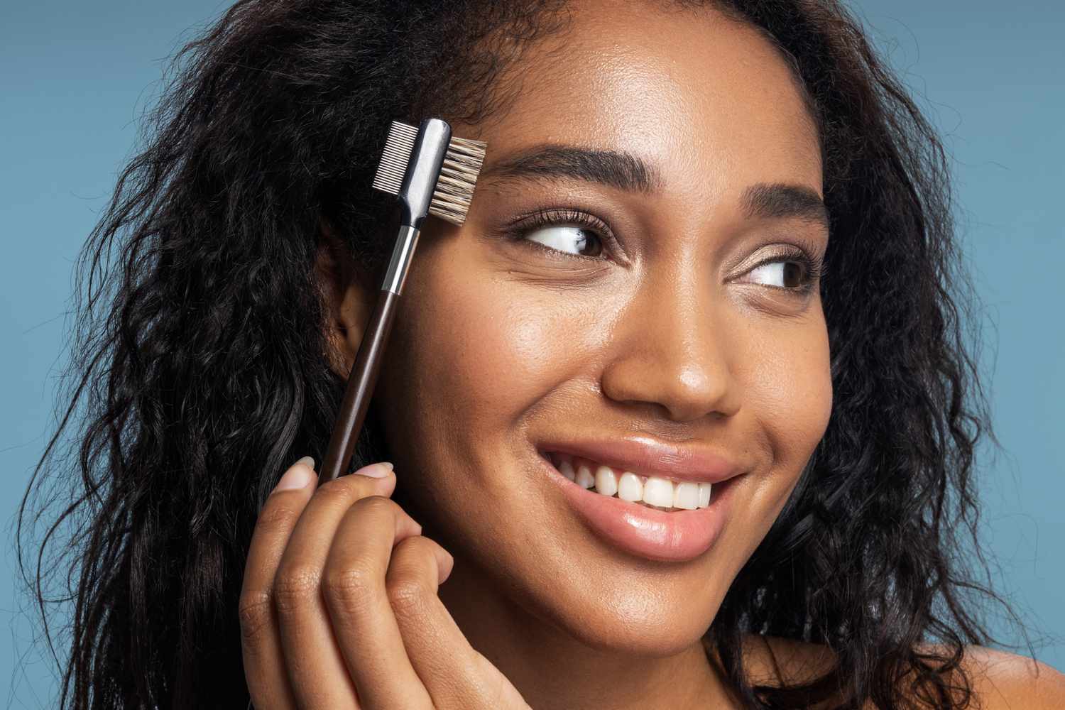 Woman grooming her own eyebrows at home