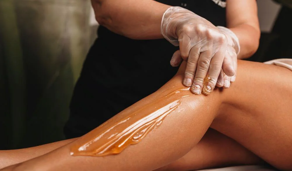Woman undergoing a hair waxing procedure on her legs